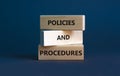 Policies and procedures symbol. Wooden blocks with words `Policies and procedures` on grey background. Business, policies and