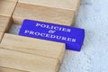 Policies and procedures text on blue wooden block separated from the rest of the blocks. Policies and procedures concept