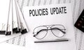 POLICIES UPDATE text on paper with chart and office tools , business concept