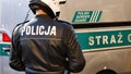 Policja Polish police officer, near a border guard vehicle, detail, policeman seen from the back, closeup, editorial news shot,