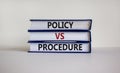 Policy vs procedure symbol. Books with words `Policy vs procedure` on beautiful white table, white background. Business and poli