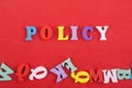 POLICY word on red background composed from colorful abc alphabet block wooden letters, copy space for ad text. Learning english