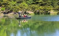 Poling a Boat Across a Pond in a Japanese Garden