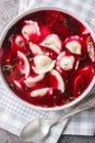 Polish beet borscht with Christmas uszka dumplings closeup on the plate on the table. Vertical top view Royalty Free Stock Photo