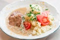 Polish dish bitki wolowe with sauce, smashed potatoes with parsley and tomato