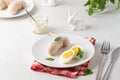 Polish Easter breakfast, white sausage and boiled egg on a white plate on a light concrete background. Served with white