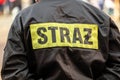 Polish firefighter uniform back with the word STRAZ reflective patch, emergency rescue service jacket closeup during response, Royalty Free Stock Photo
