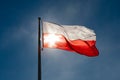 Beautiful Polish flag with blue sky and sun on background