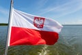 Polish flag suspended on the stern of a small inland ship. A vessel floating on a large lake in central Europe Royalty Free Stock Photo