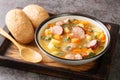 Polish Grochowka Pea soup with potatoes, onions, carrots, bacon and sausages close-up in a bowl. Horizontal Royalty Free Stock Photo