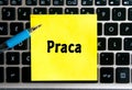 The polish inscription `Praca` on a yellow sheet of sticker paper