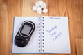 Polish inscription world diabetes day in notebook, glucometer and sugar cubes