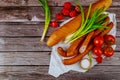 Polish kielbasa with vegetables and bread on wooden background Royalty Free Stock Photo