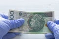 Poland money, one hundred zlotys banknotes kept in rubber gloves. The concept of economy and financial threats during the Coronav
