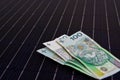 Polish money on solar panel surface. Renewable energy cost