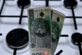 Polish money zloty in hand on the background of a gas stove Royalty Free Stock Photo