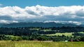 Meadow, forest and rainy clouds over the mountains Royalty Free Stock Photo