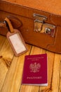 Polish passport and travel suitcase on a wooden table. Accessories for the traveler before the international trip