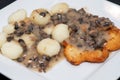 Polish Potato Drop Dumplings and Breaded Chicken Breast in Mushroom Sauce on plate.