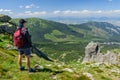 Polish Tatra Mountains, a young man in shorts and a cap with a mountain backpack stands on the mountainside Royalty Free Stock Photo