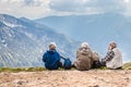 Polish Tatras Poland June 3 2019: elderly people with backpacks are sitting on the ground high in the mountains. An old man looks Royalty Free Stock Photo