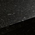 Polished black granite countertop featuring a smooth surface with a speckled pattern Royalty Free Stock Photo