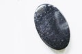 Polished black tourmaline gemstone on a white background