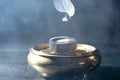 Polished bronze pot with a charcoal disk on it releasing smoke Royalty Free Stock Photo