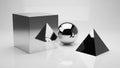 Polished chrome cube, reflective sphere, and matte black pyramid arranged on a white surface Royalty Free Stock Photo