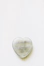 Polished fluorite stone in the shape of a heart on a white background