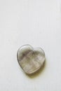 Polished fluorite stone in the shape of a heart on a white background