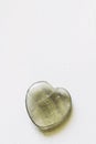 Polished fluorite stone in the shape of a heart on a white background