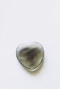 Polished fluorite stone in the shape of a heart on a white background