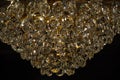 Polished glass texture closeup. Sparkle crystal hangings of luxury chandelier on black background. Vintage hexagon glass surface