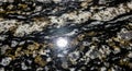 Polished granite surface with a complex pattern of swirling black, white, and gold Royalty Free Stock Photo