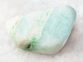 polished green Aragonite gemstone on white