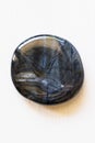 Polished hawkeye gemstone on a white background