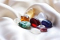 polished healing stones on a white satin sheet Royalty Free Stock Photo