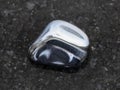 polished hematite gem on dark granite background