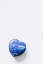 Polished lapis lazuli stone in the shape of a heart on a white background