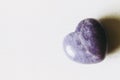 Polished lepidolite lilac stone in the shape of a heart on a white background Royalty Free Stock Photo