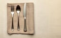 Polished metal cutlery placed on linen napkin Royalty Free Stock Photo