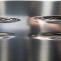 Polished metal surface with a reflective finish, displaying distorted reflections and smooth, Royalty Free Stock Photo