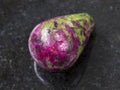 polished pink and green zoisite gemstone on dark