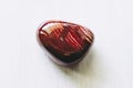 Polished red banded jasper gemstone on a white background