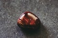 Polished red banded jasper gemstone on a black background