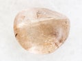 polished Rutilated Quartz gemstone on white marble Royalty Free Stock Photo