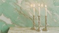 Polished Silver Candlesticks with Lit Candles on Elegant Marble Surface Against Marble Wall Background. Copy space Royalty Free Stock Photo