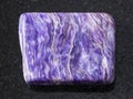 Polished slab of charoite gemstone on dark Royalty Free Stock Photo