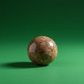 A polished stone sphere with a smooth, glossy surface sits on a vibrant green Royalty Free Stock Photo